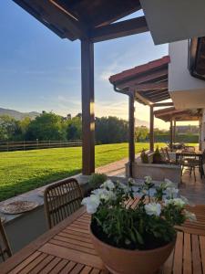 a patio with a table with flowers in a pot at Terradeva Apartamentos in Colombres