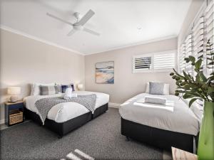 a bedroom with two beds and a ceiling fan at Lang Chalet - Vineyard Bliss on the Waterfront in Wilyabrup