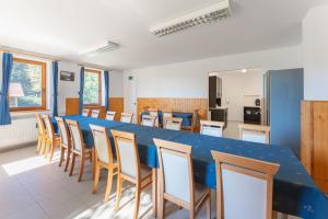 ein großer Raum mit einem langen blauen Tisch und Stühlen in der Unterkunft Diana Vendégház in Bükkösd