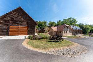 eine alte Scheune mit einem Wagen davor in der Unterkunft Diana Vendégház in Bükkösd