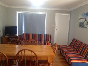 a living room with a wooden table and chairs at Green Meadow in Nowra