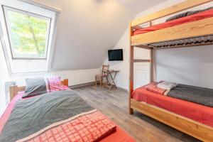 ein Schlafzimmer mit zwei Etagenbetten und einem Schreibtisch in der Unterkunft Diana Vendégház in Bükkösd + 8 Fotos