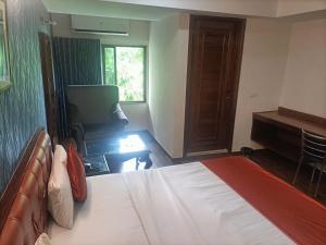 アーメダバードにあるHotel Seven Innのベッドと机があるホテルの部屋