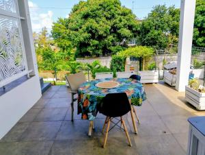 a patio with a table and chairs on a balcony at El-Sangha Studio 2mina pieds de la plage de baie du cap in Ruisseau Créole