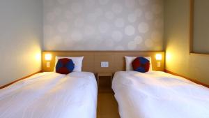two beds sitting next to each other in a room at Onyado Nono Kanazawa in Kanazawa
