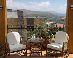 埃赫登Beyt El Midan的美景阳台配有两把椅子和一张桌子