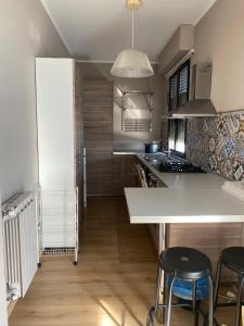 a kitchen with a counter and some stools in it at Attico fronte mare con terrazzo in Pescara
