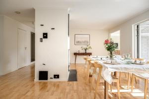 a white dining room with a table and chairs at Villa med privat läge nära Elmia in Huskvarna