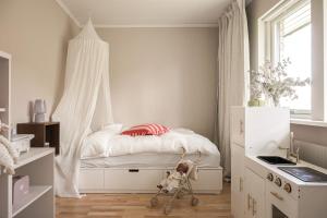 a small white bedroom with a bed with a canopy at Villa med privat läge nära Elmia in Huskvarna