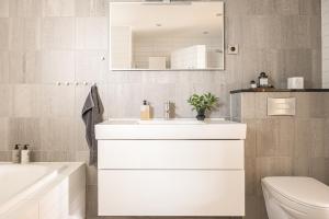 a bathroom with a sink and a toilet and a mirror at Villa med privat läge nära Elmia in Huskvarna +22 photos