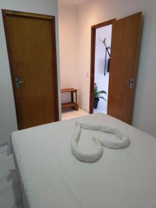 Una cama con una manta blanca encima. en Pousada Apart Praia Uruaú, en Beberibe