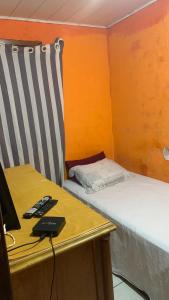a room with two beds and a desk with a laptop at Rústica Chapas P in Lençóis