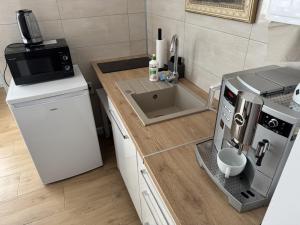 a kitchen with a counter with a microwave and a sink at ViLLA ZAKĄTEK in Grzybowo