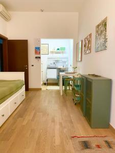 ein Schlafzimmer mit einem Bett, einem Tisch und einem Schreibtisch in der Unterkunft Michelangelo Green Corner in Casalecchio di Reno