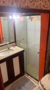 a bathroom with a shower and a sink and a mirror at Rústica Chapas P in Lençóis