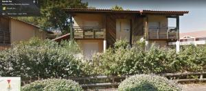 een huis met een balkon en struiken ervoor bij Entre mer et golf in Moliets-et-Maa