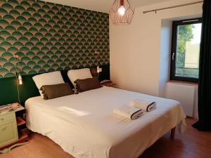Un dormitorio con una gran cama blanca con toallas. en La Canopée, 