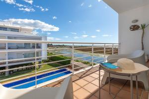 a balcony with a view of a swimming pool at Apartment Calma, Formosa Village in Fuzeta