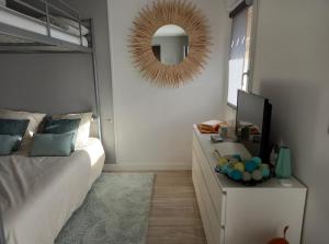 een slaapkamer met een bed en een spiegel aan de muur bij Entre mer et golf in Moliets-et-Maa