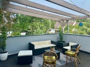 a patio with chairs and tables and a pergola at Ferienwohnung Südstraße Dachterrasse in Eschede