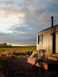 a woman sitting on a bench next to a building at Polaris in Kelsall