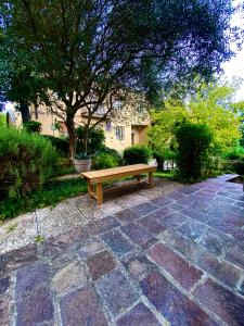 eine Holzbank auf einer Backsteinterrasse in der Unterkunft Michelangelo Green Corner in Casalecchio di Reno