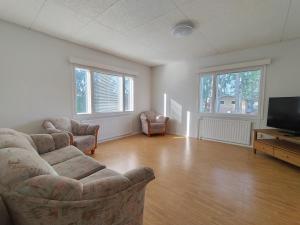 an empty living room with a couch and a television at Villa Green in Kruunupyy