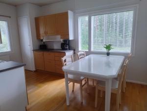 a kitchen with a white table and chairs at Villa Green in Kruunupyy
