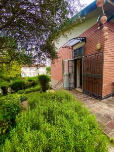 einem roten Backsteingebäude mit einer Tür und einem Hof in der Unterkunft Michelangelo Green Corner in Casalecchio di Reno