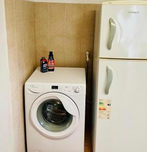 a washing machine in a kitchen next to a refrigerator at Departamento Cómodo con Cochera in Villa Mercedes