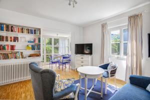 a living room with a table and chairs at Ferienwohnungen Benzenberg in Tutzing