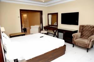 a hotel room with a bed and a chair and a television at Shalimar Hotel in Multan