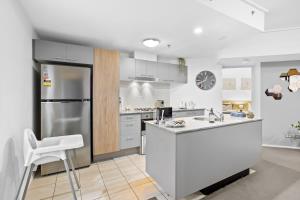 cocina blanca con nevera y encimera en Modern 2BR in Brisbane CBD Free Parking and Pool, en Brisbane