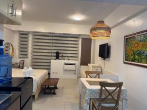 uma cozinha e sala de estar com duas camas e uma mesa em Telly's Studio Across NAIA3 em Manilla