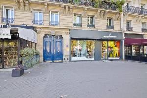 un edificio con una puerta azul en una calle en Arc de Triomphe - Luxurious 3 Bedroom with NetFlix, en París