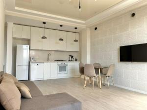 a living room with a table and a kitchen at Sunny apartment in Tbilisi City +3 photos