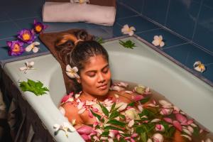 a woman in a bath tub filled with flowers at COLOMBO Eco Lodge & Wellness Centre in Colombo +29 photos