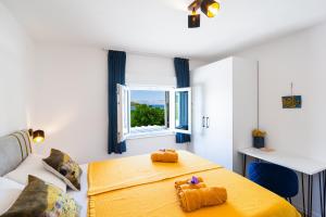 Un dormitorio con una cama amarilla y una ventana. en Smiljin Dvor, en Nečujam