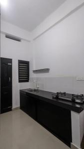 a kitchen with a black counter top and a black door at Anam residence in Tāzhekkod