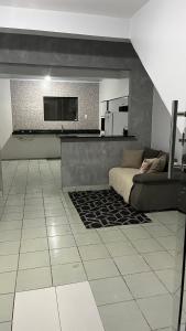 a living room with a couch and a flat screen tv at Casa da folha 12 in Marabá