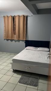 a bed sitting in a room with a window at Casa da folha 12 in Marabá