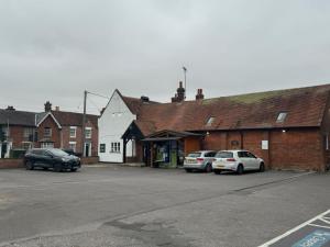 a parking lot with cars parked in front of a building at The Bull Hotel in Downton