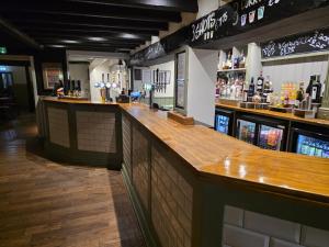 a bar with a wooden counter in a restaurant at The Bull Hotel in Downton +9 photos