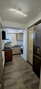 una cocina con refrigerador y lavadora y secadora en Loft Craiova Apartament, en Craiova 3 fotos más