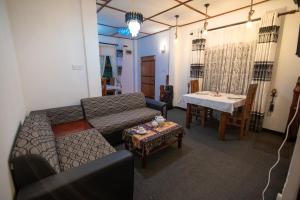 努沃勒埃利耶Top View Cottage的客厅里有一张沙发和一张桌子。