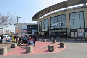 a shopping center with people outside of a building at Le Vallès in Courcouronnes