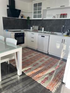 a kitchen with white cabinets and a table and a rug at Villa the Moon in Dalaman +17 photos