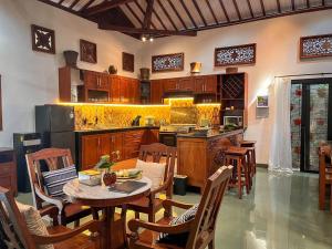 a kitchen with a table and some chairs and a counter at Ndalem Srigading Villa Solo in Bonorejo