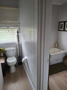 a bathroom with a toilet and a tub and a sink at Notre Petit Paradis in Mossel Bay +12 photos