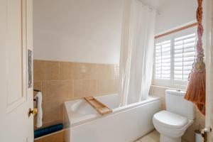 ein Badezimmer mit Badewanne, Toilette und Waschbecken in der Unterkunft Victorian Cartref in the heart of Llandudno in Llandudno + 58 Fotos